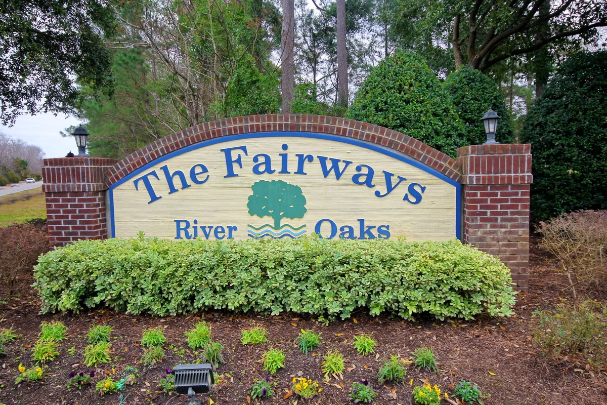 Community signage amid manicured landscaping and elegant lighting fixtures. The signage marks the entrance to the community, conveying a sense of arrival and the well-maintained, welcoming atmosphere of the property.